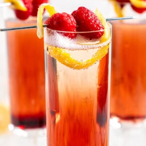 3 kir royales with raspberries and lemon twist