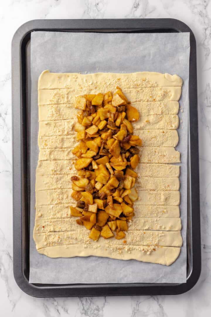 Overhead view of apple strudel with pastry cut into strips