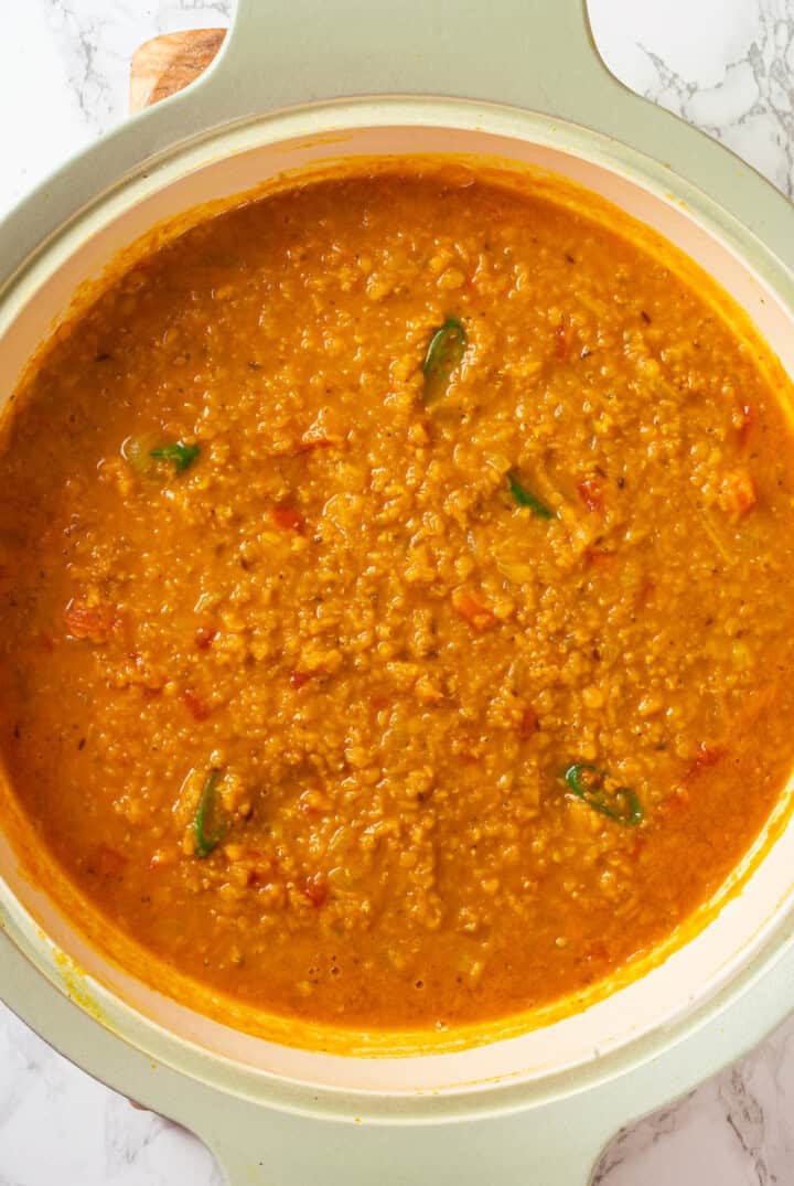 Overhead view of red lentil dal in pan