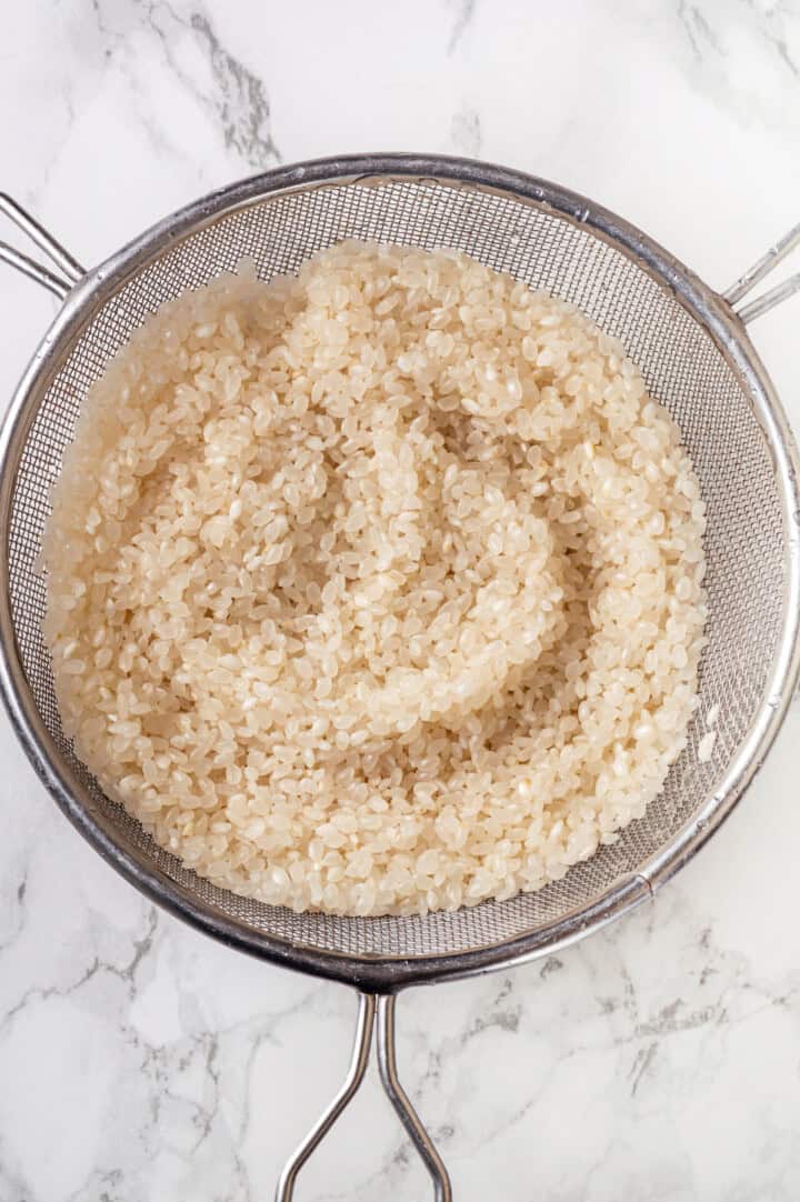 Draining sushi rice in colander