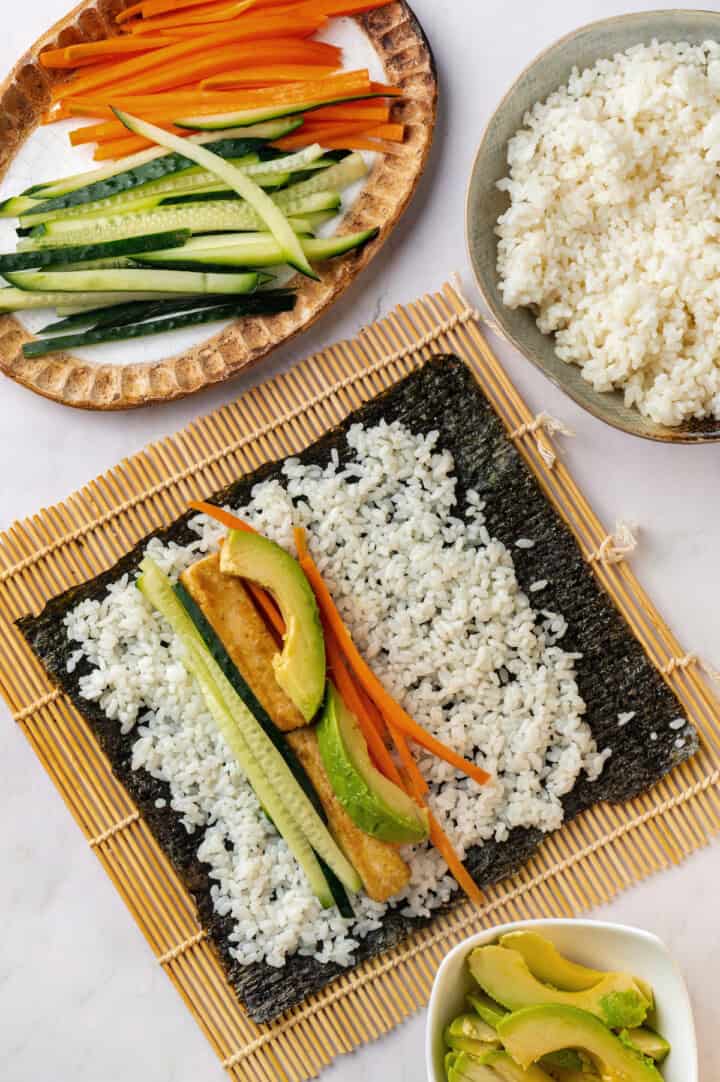 Assembling vegan sushi on bamboo mat