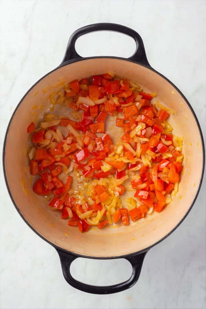 Onions and red pepper cooking in Dutch oven