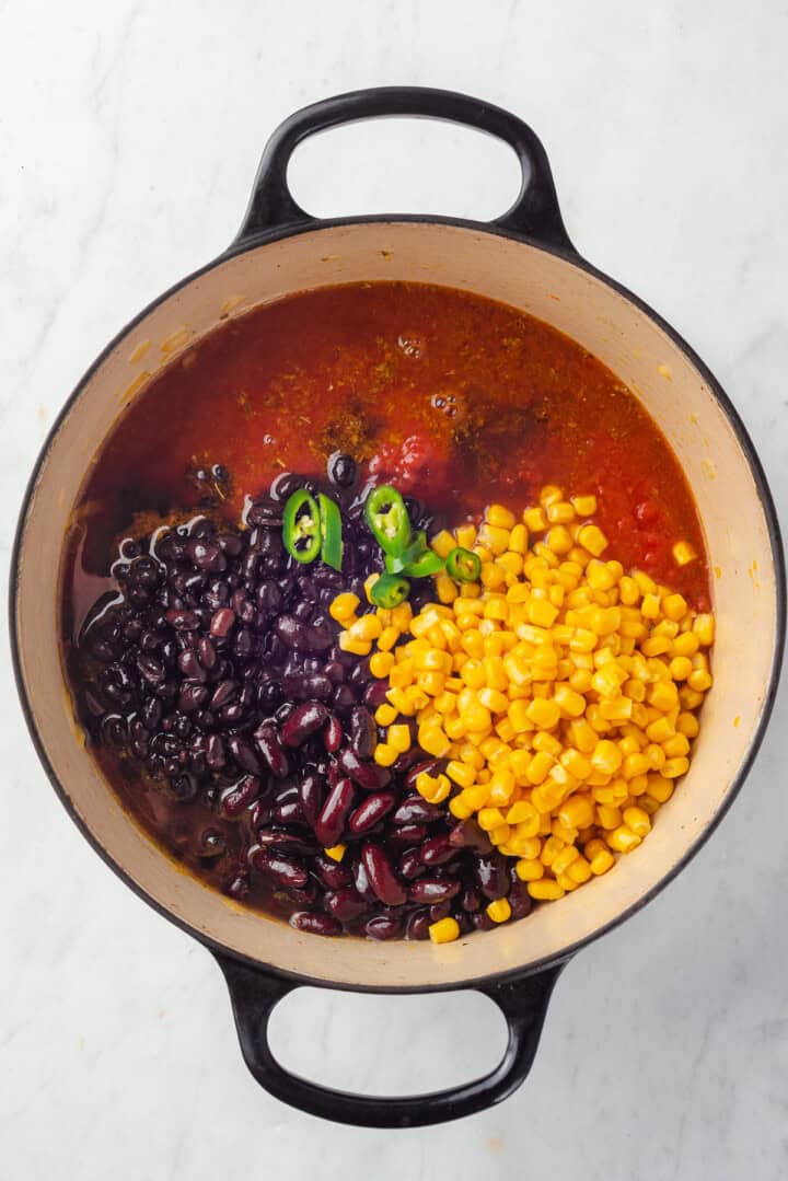 Beans, corn and chili pepper added to pot of taco soup