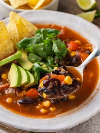 Spoonful of taco soup held over bowl