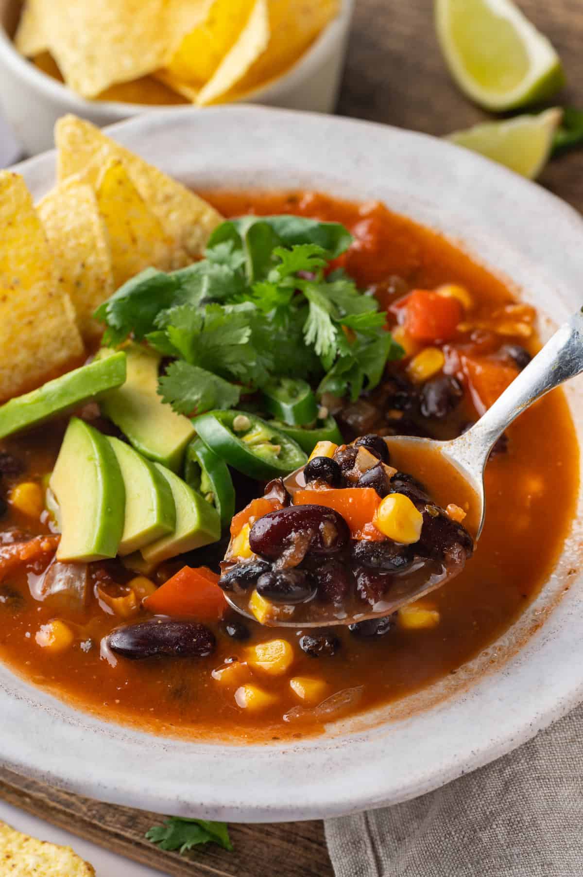 Spoonful of taco soup held over bowl