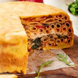 Timpano on cutting board with slices removed to show layers inside