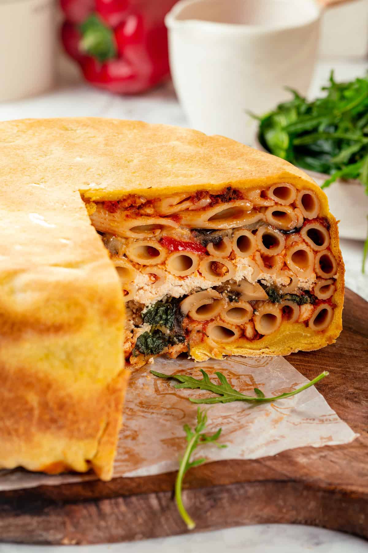 Sliced vegan timpano on cutting board to show layers inside