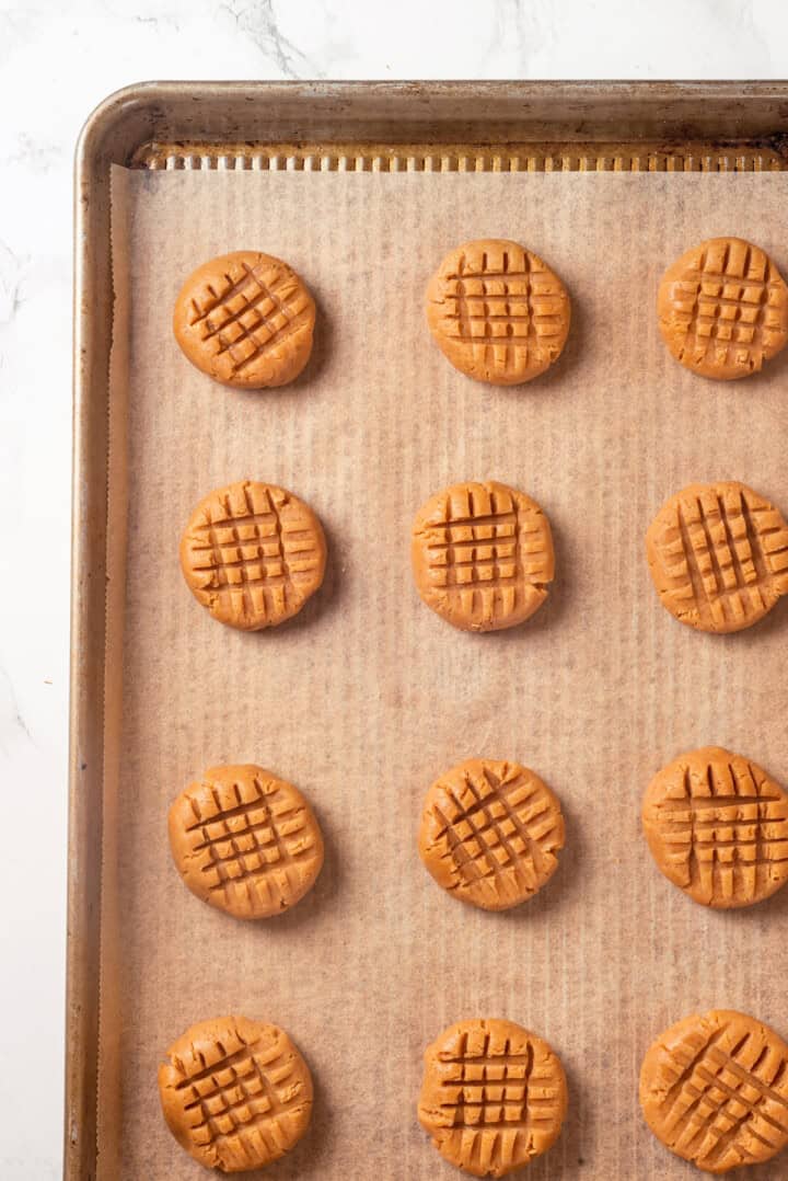 Overhead view of peanut butter cookies on baking sheet before baking