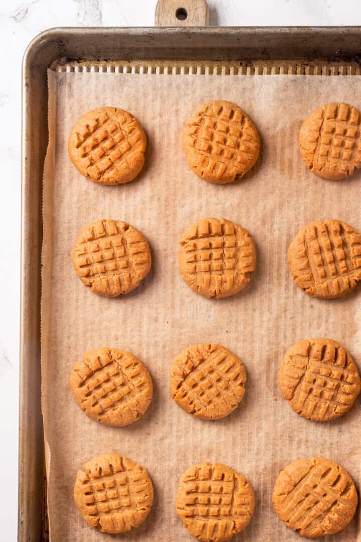 Overhead view of peanut butter cookies on parchment-lined baking sheet