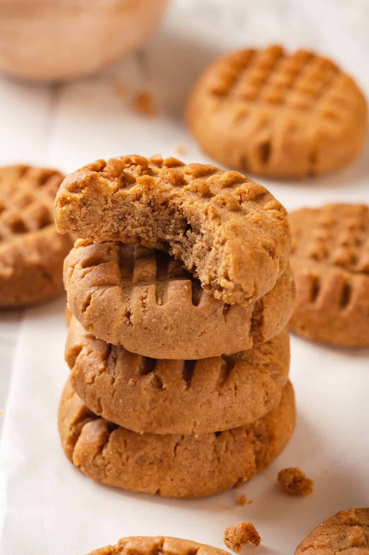 Stack of 3 vegan peanut butter cookies with top cookie bitten