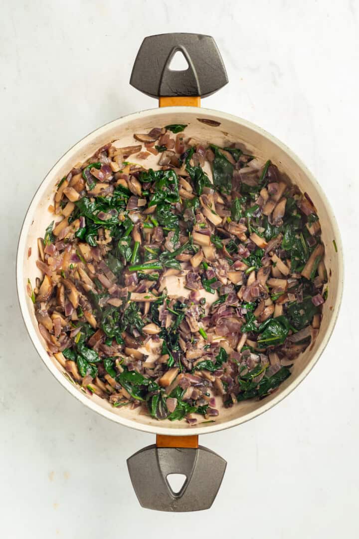 Spinach, mushrooms, and other filling ingredients in pan