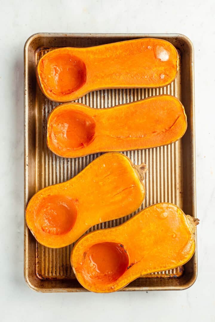 Roasted butternut squash halves on baking sheet