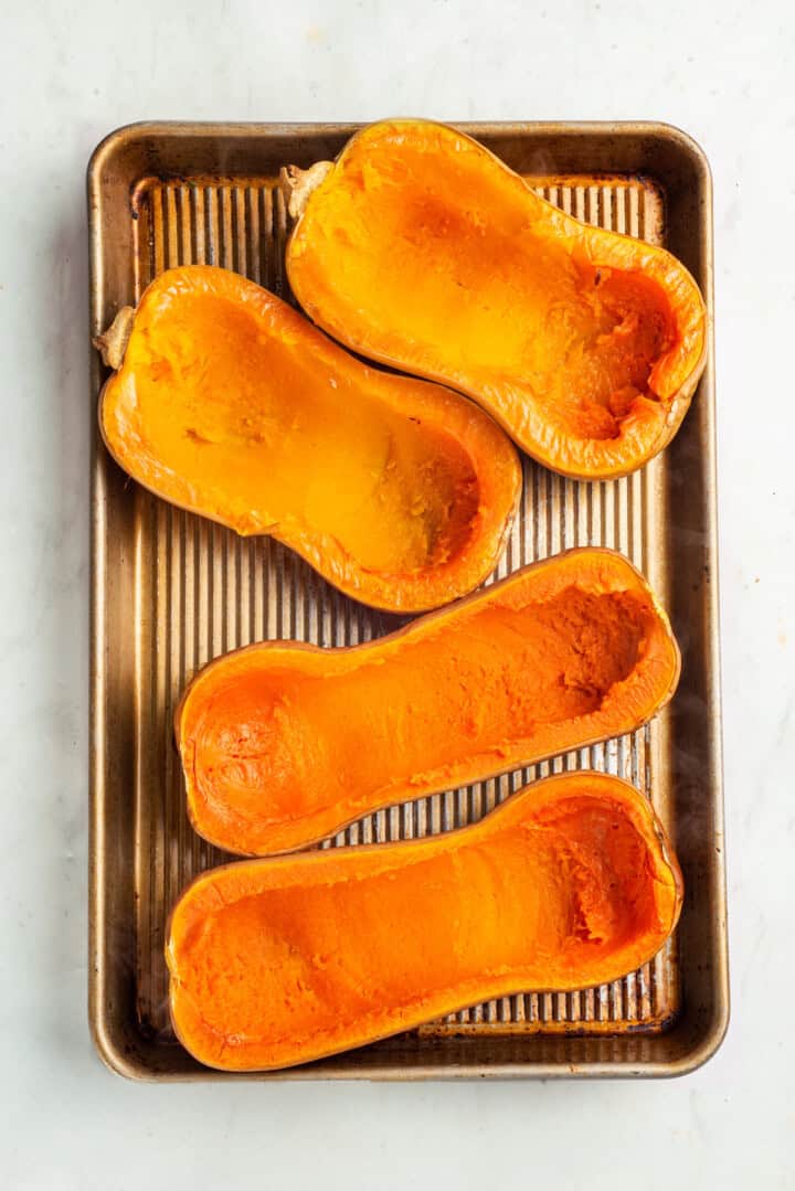 Hollowed butternut squash shells on baking sheet