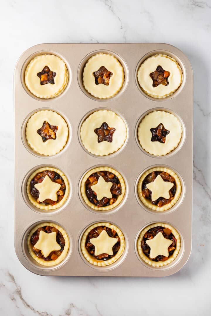 Overhead view of unbaked mince pies in pan