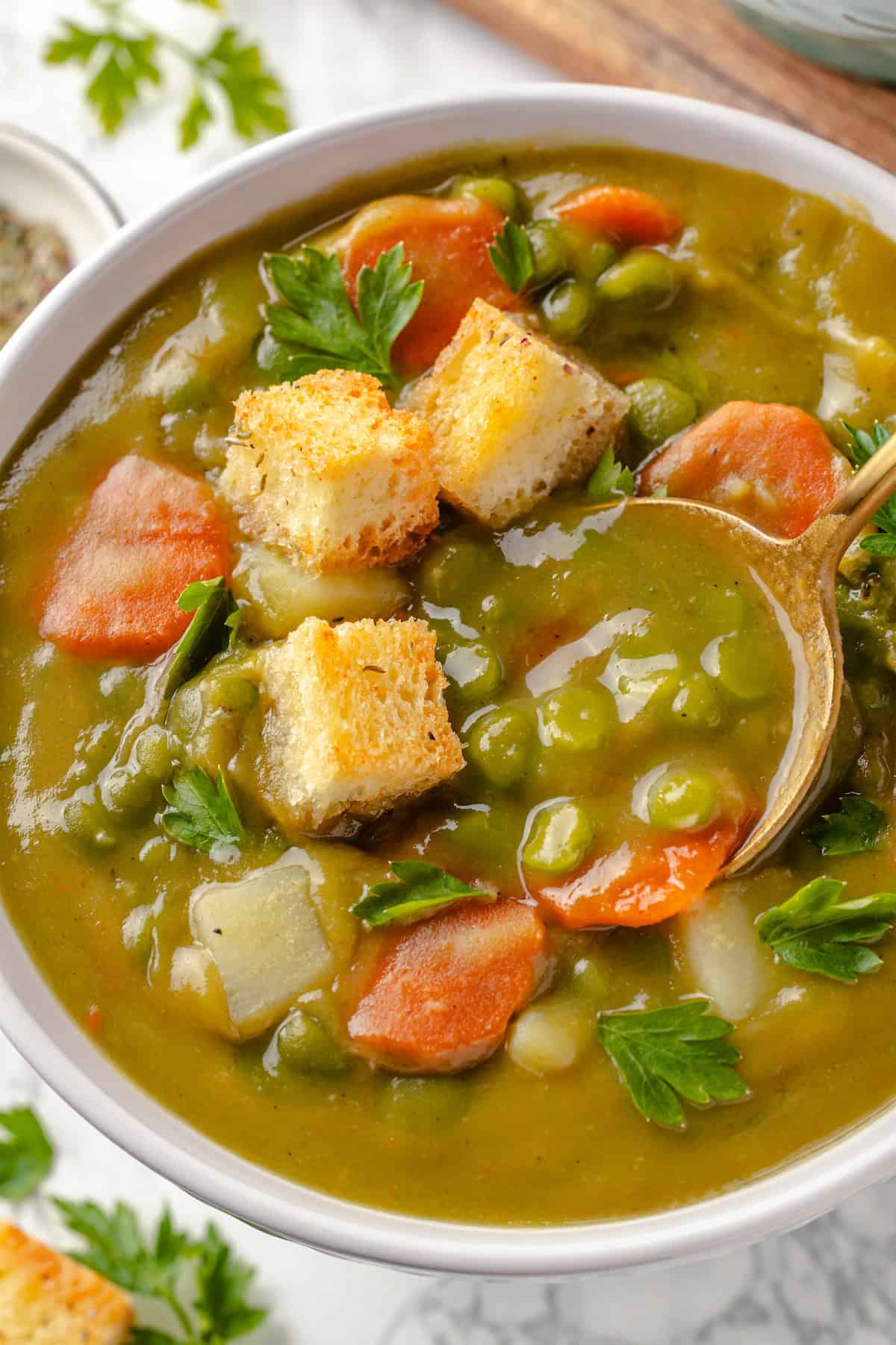 Spoon digging into bowl of split pea soup