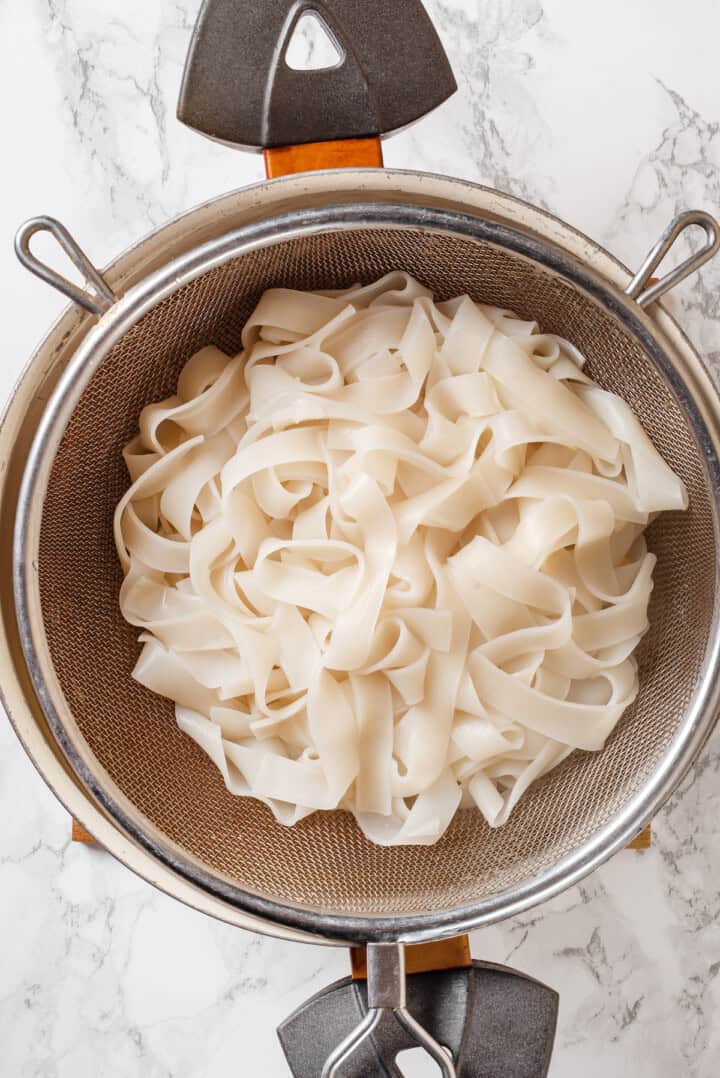 Cooked rice noodles in colander