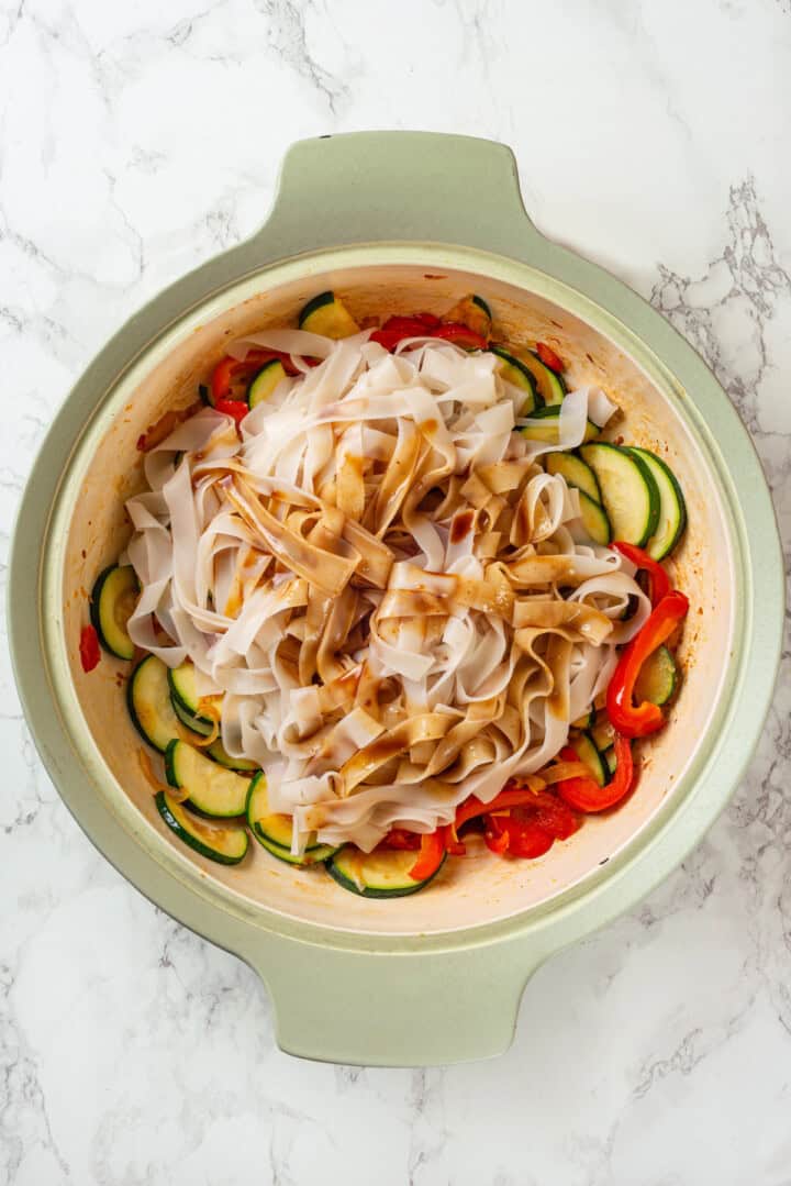 Noodles and sauce added to skillet with vegetables