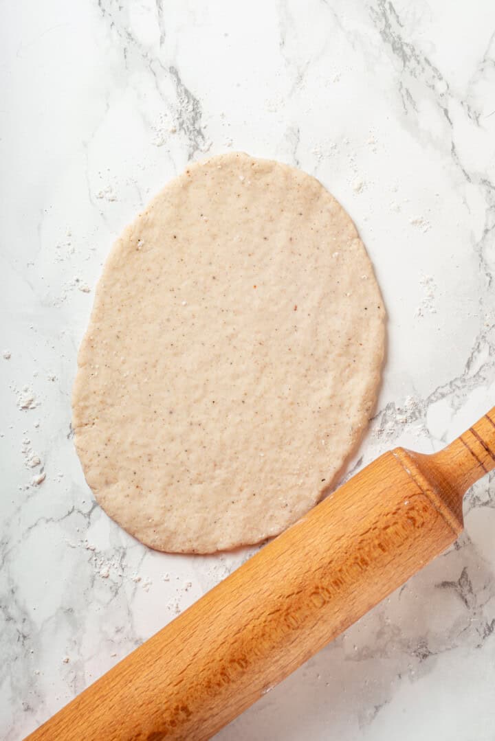 Rolling out gluten-free naan dough with rolling pin