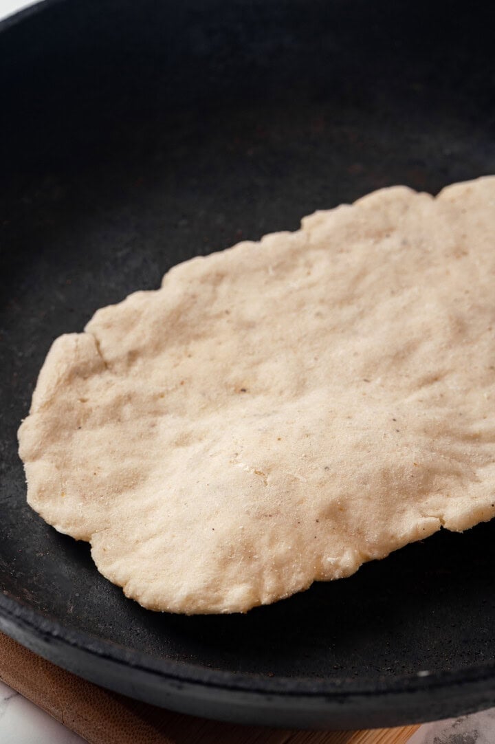 Naan dough placed into cast iron skillet