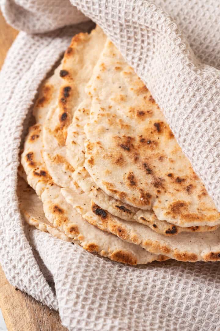 Cooked naan wrapped in kitchen towel