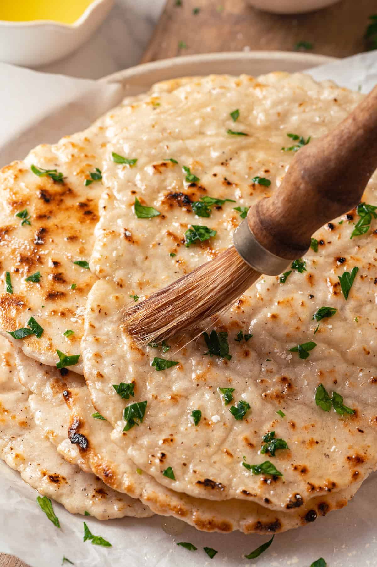 Brushing gluten-free naan with melted butter