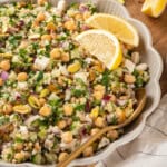 Jennifer Aniston salad in serving bowl with lemon wedges