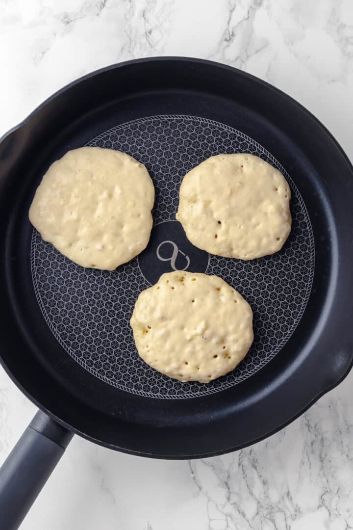 Vegan banana pancakes in skillet before flipping