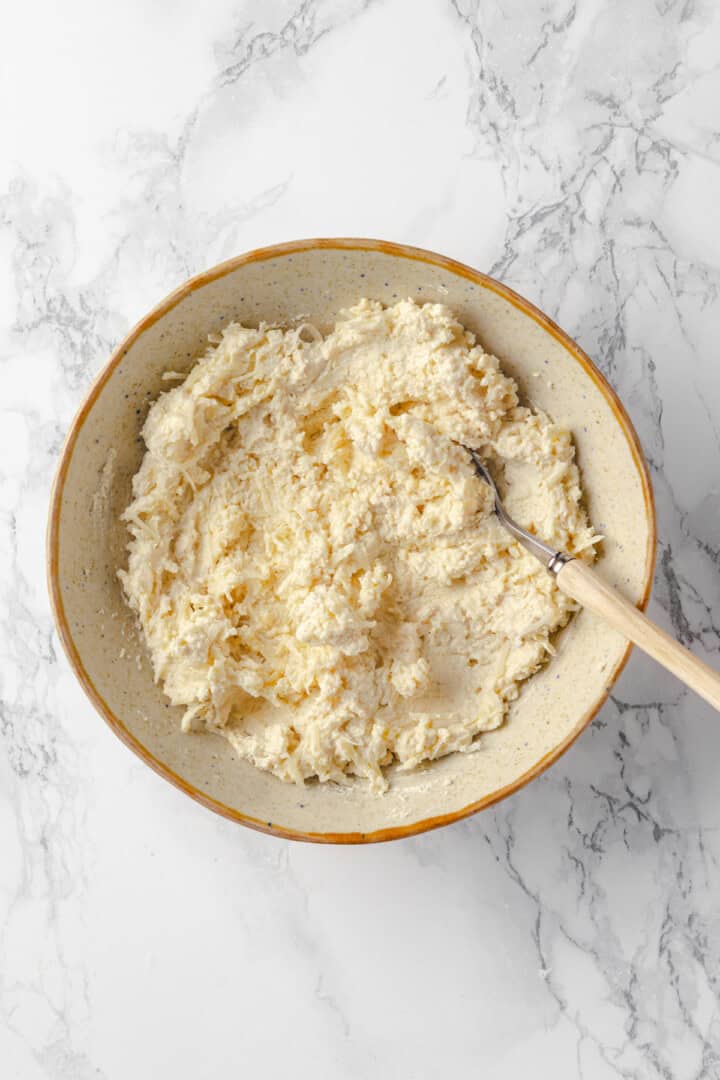 Overhead view of vegan ricotta mixture in bowl with spoon