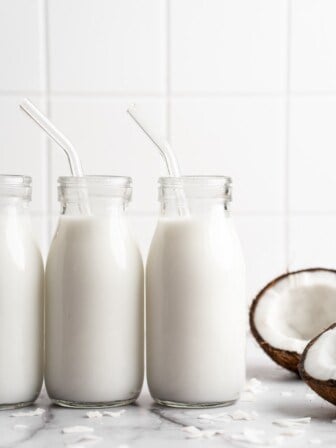 3 bottles of homemade coconut milk lined up on counter