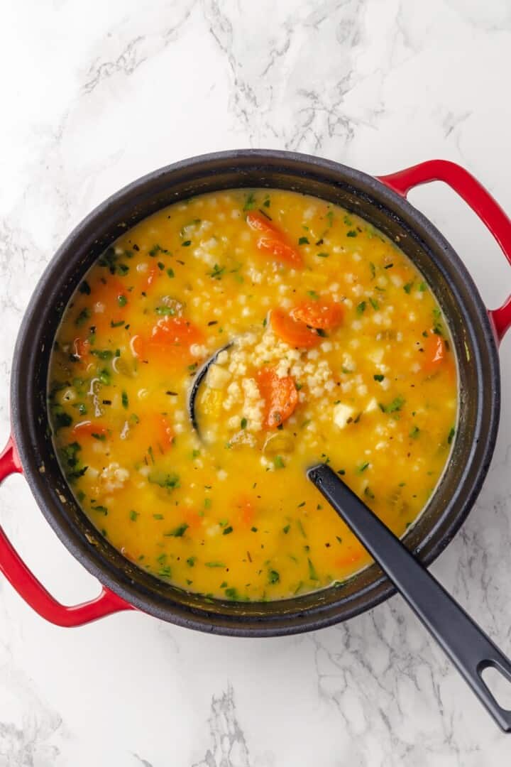 Overhead view of Italian penicillin soup in pot with ladle