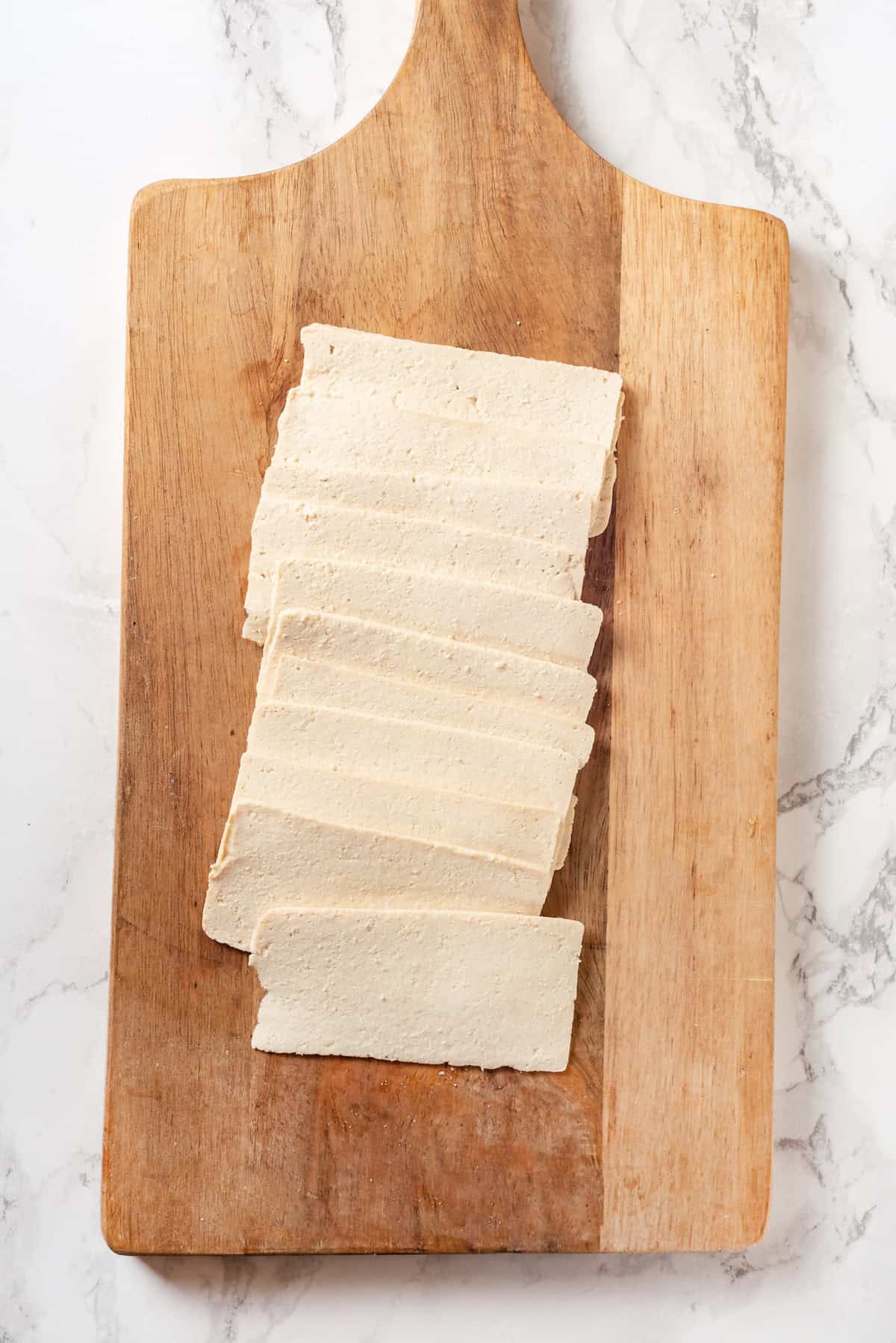 From crispy baked tofu to saucy stir-fries, these tofu recipes make every meal easier with flavourful, protein-packed dishes everyone loves! Slices of tofu on cutting board