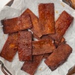 Overhead view of tofu bacon on parchment paper