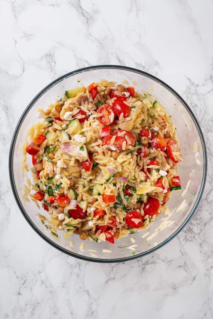 Overhead view of orzo pasta salad in glass bowl