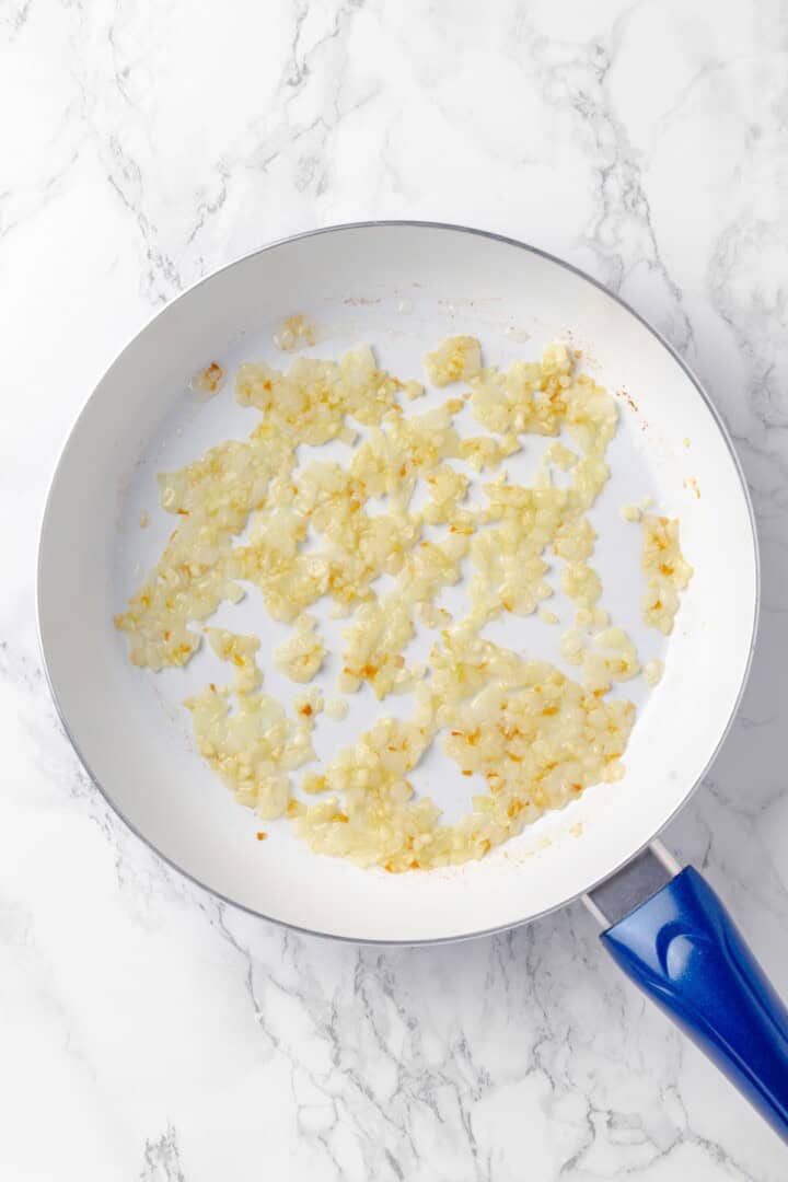 Overhead view of onion cooking in skillet