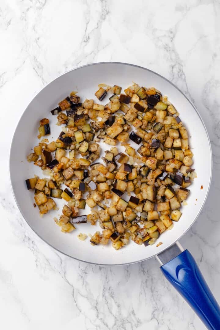 Overhead view of eggplant cooking in skillet