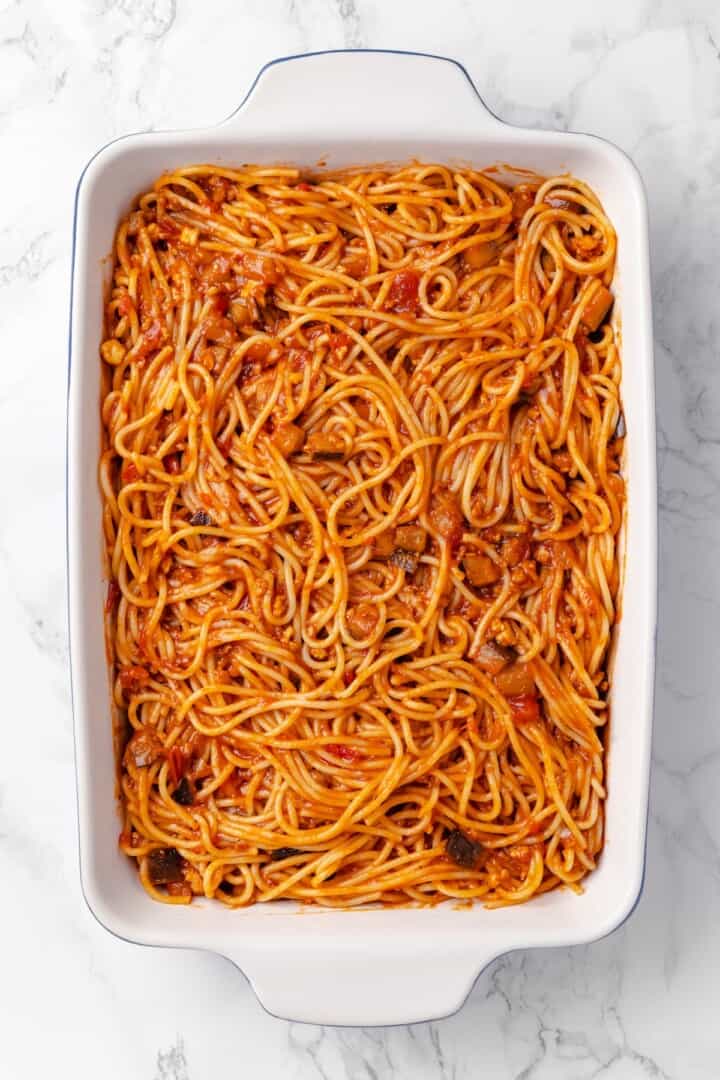 Overhead view of spaghetti and sauce in dish before adding cheese