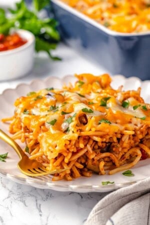 Square of vegan baked spaghetti on plate with fork