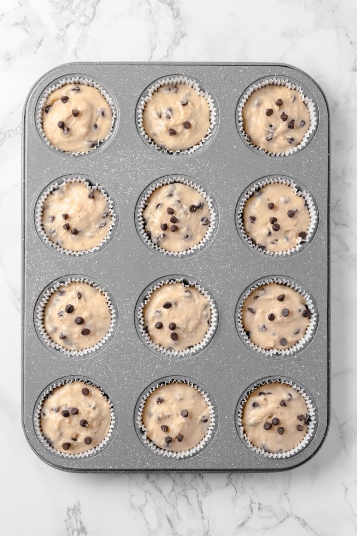 This moist and fluffy vegan chocolate chip muffin recipe is made with simple ingredients and easy enough that you can whip it up in minutes! Overhead view of batter in muffin pan