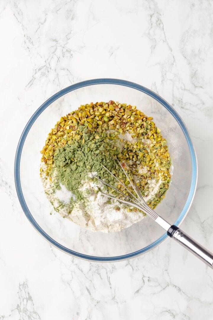 Overhead view of dry ingredients for pistachio cake in bowl before whisking