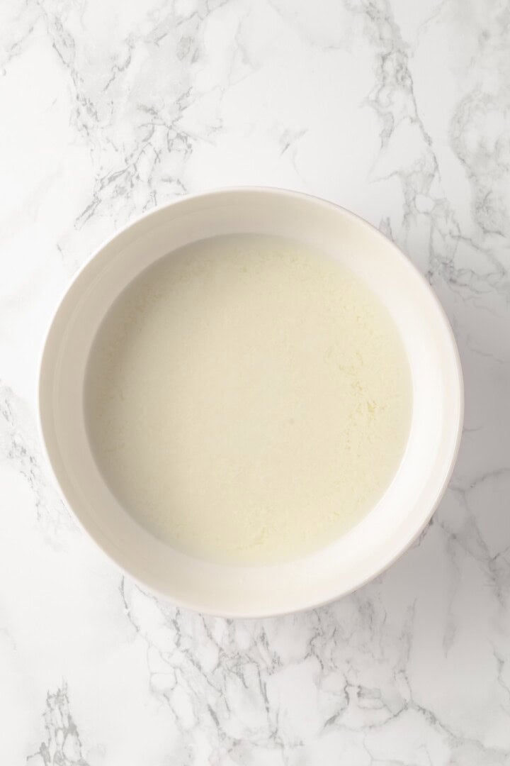 Overhead view of liquid ingredients for pistachio cake before adding coloring