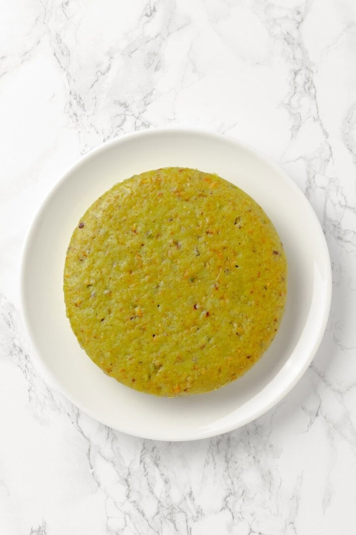 Overhead view of pistachio cake on platter before frosting