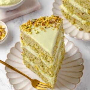 Slice of vegan pistachio cake on plate with fork