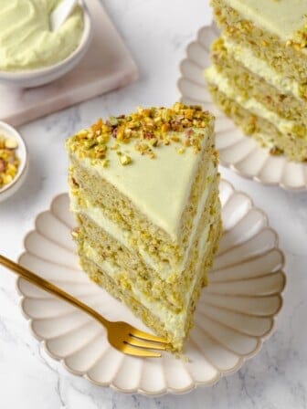 Slice of vegan pistachio cake on plate with fork