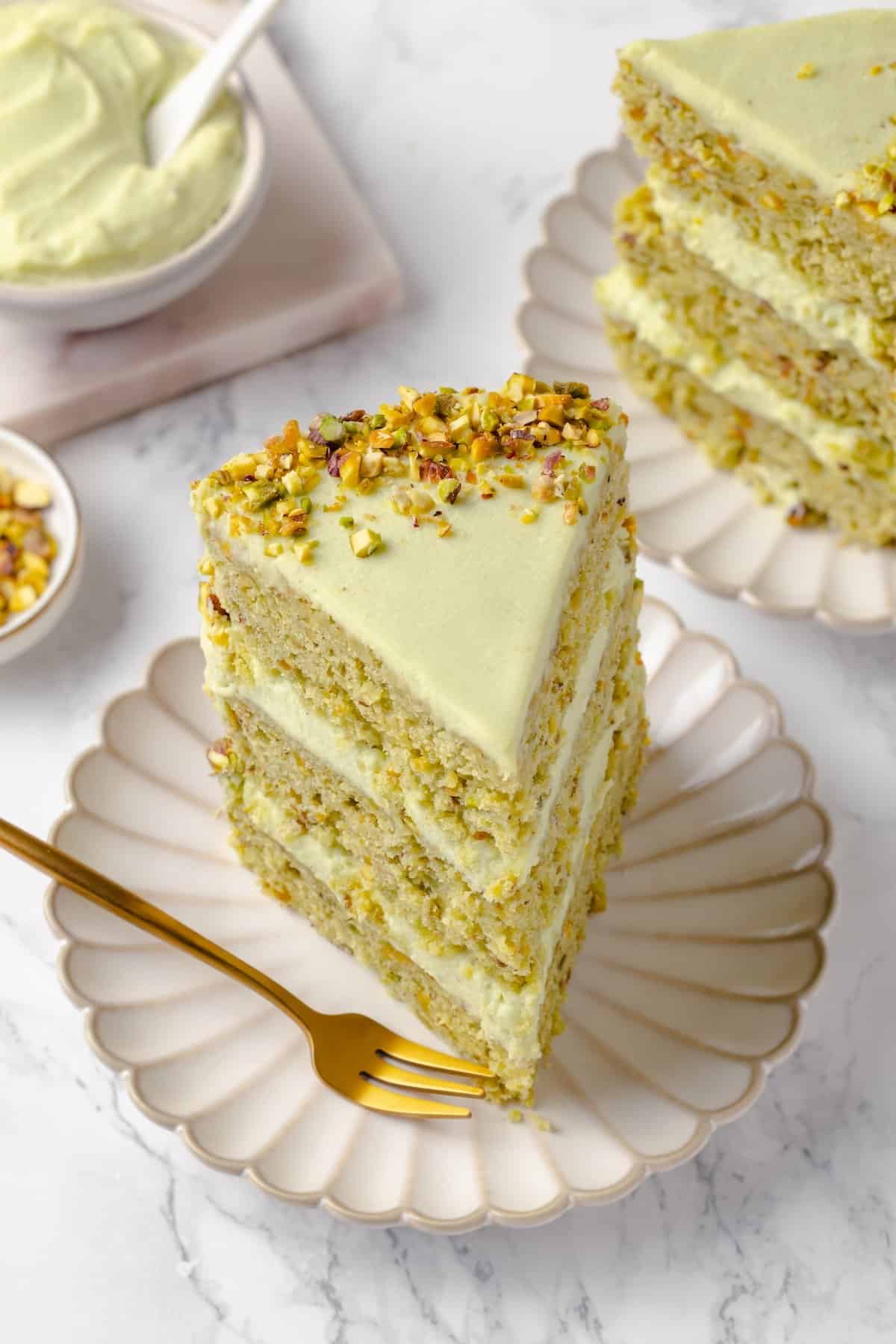 Slice of vegan pistachio cake on plate with fork