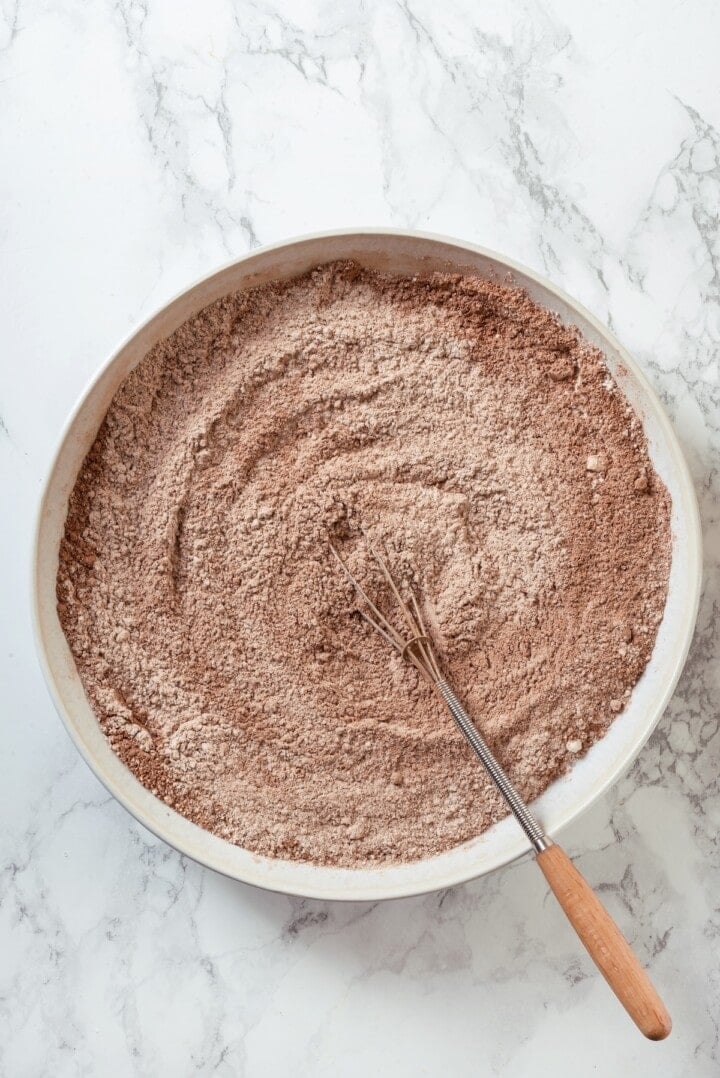 Overhead view of dry ingredients in mixing bowl with whisk