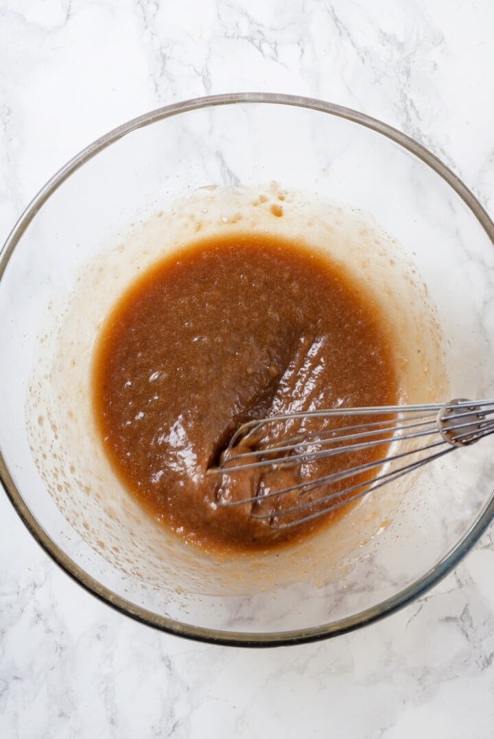 Overhead view of wet ingredients in mixing bowl with whisk