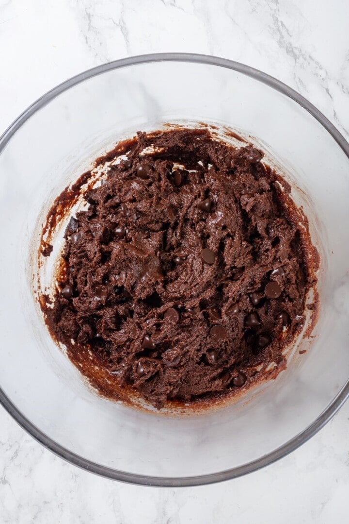 Overhead view of double chocolate chunk cookie dough in glass bowl