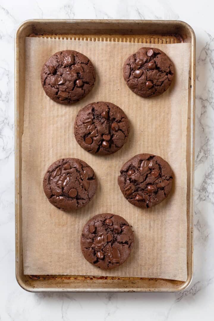Overhead view of double chocolate chunk cookies on parchment-lined baking sheet