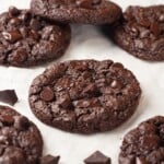 Chewy double chocolate chunk cookies on parchment paper