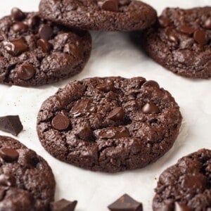 Chewy double chocolate chunk cookies on parchment paper